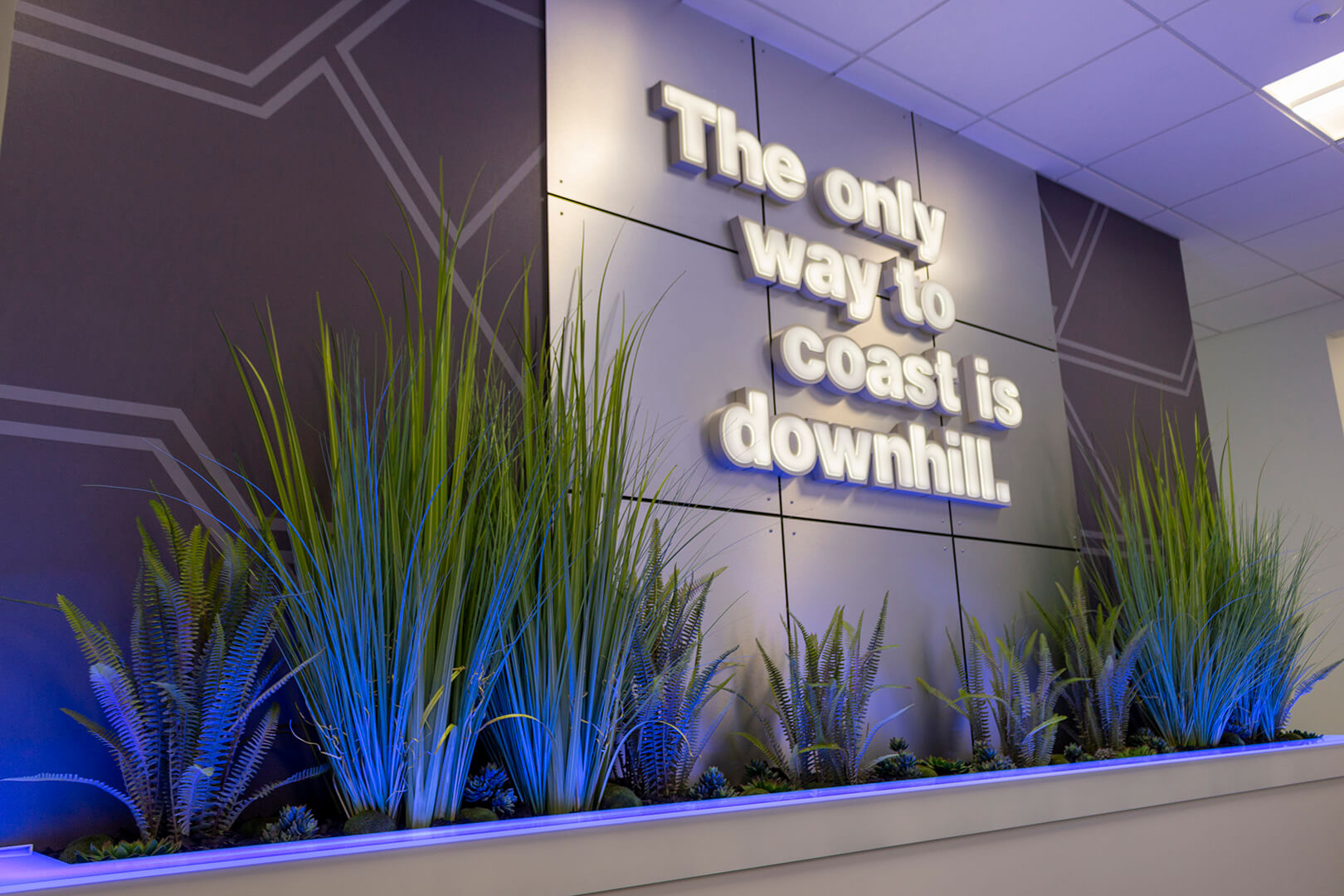 Quote wall reading "the only way to coast is downhill," created by ZENTX for Saginaw Control and Engineering's offices