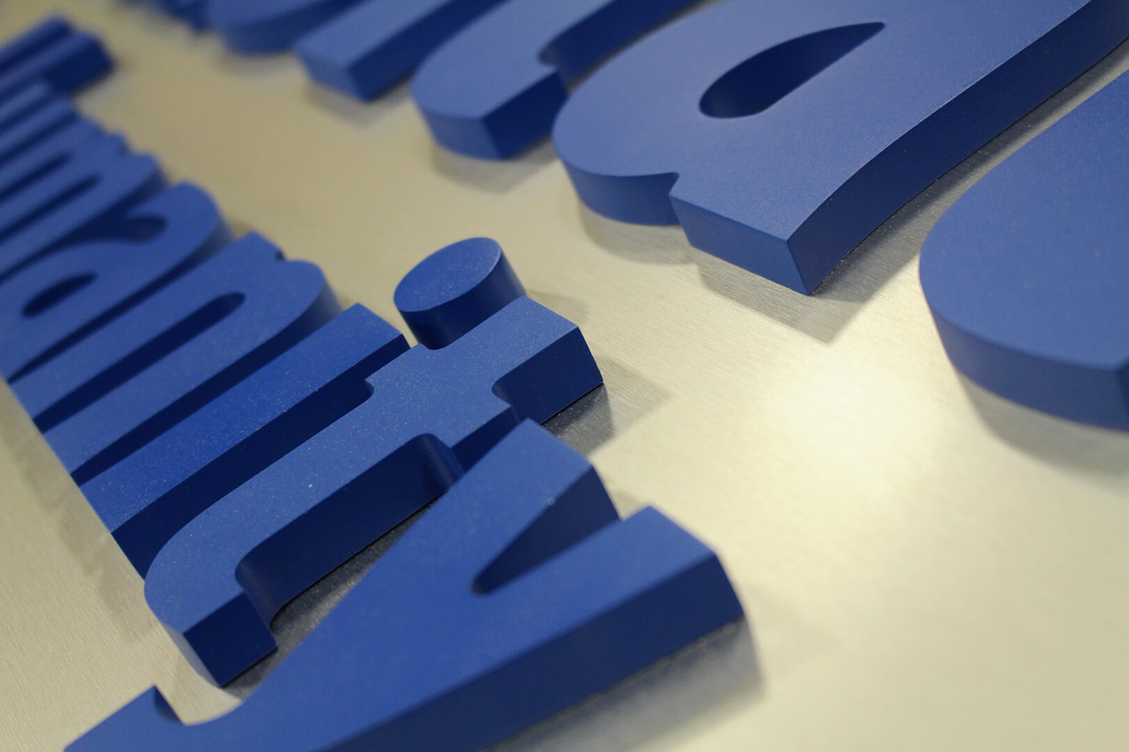 Closeup of dark blue dimensional elements on reflective signage